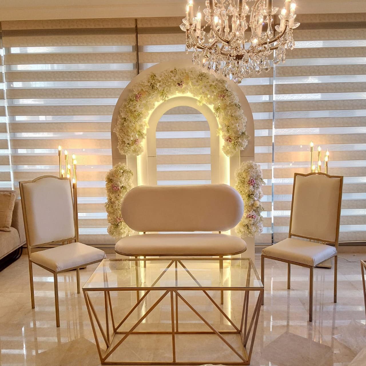 Couple lounge seating framed by a glowing floral arch